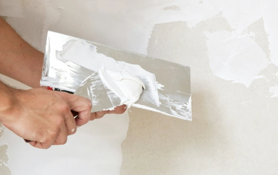 Construction workers are applying wall plaster.